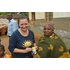In the photo there are several people in a village. Two women are holding a pack of cloves.