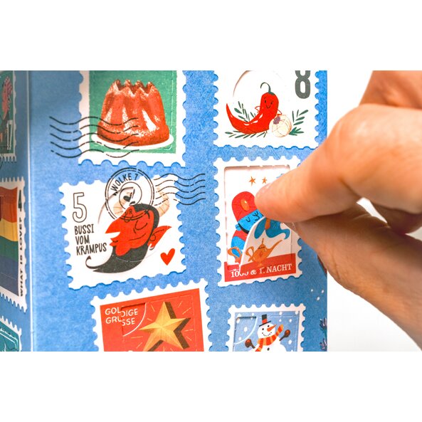 Hand opening a small door of the spice advent calendar with festive stamp motifs