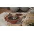 Shown is an incense burner with an incense charcoal and herbs on it. Around there are also many herbs. | © Florian Bauer